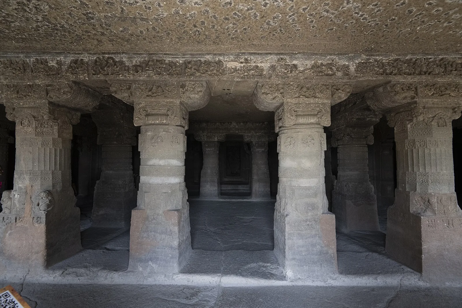 A carved cave front cut into the hillside at the Aurangabad Caves