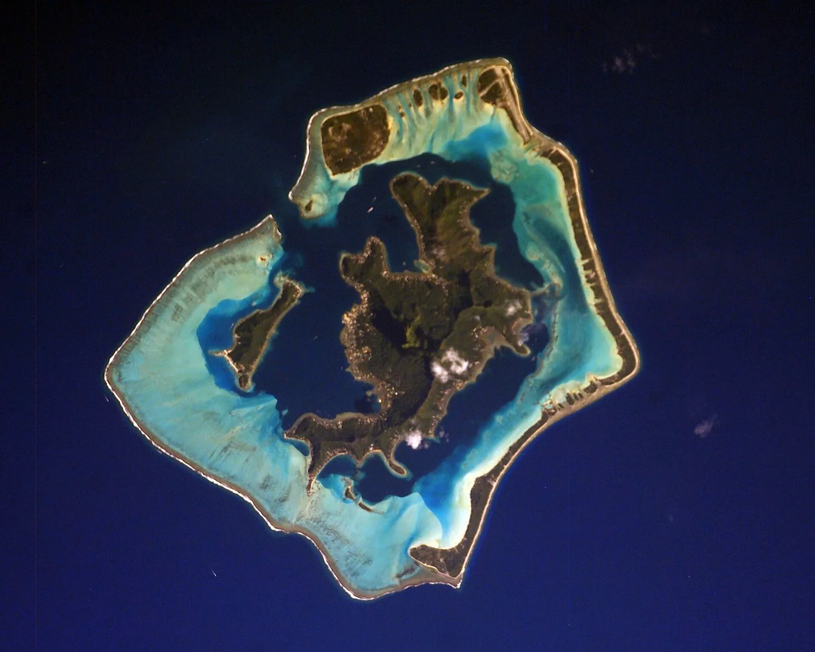Satellite-style view of Bora Bora’s reef and lagoon from space, showing vivid blue waters