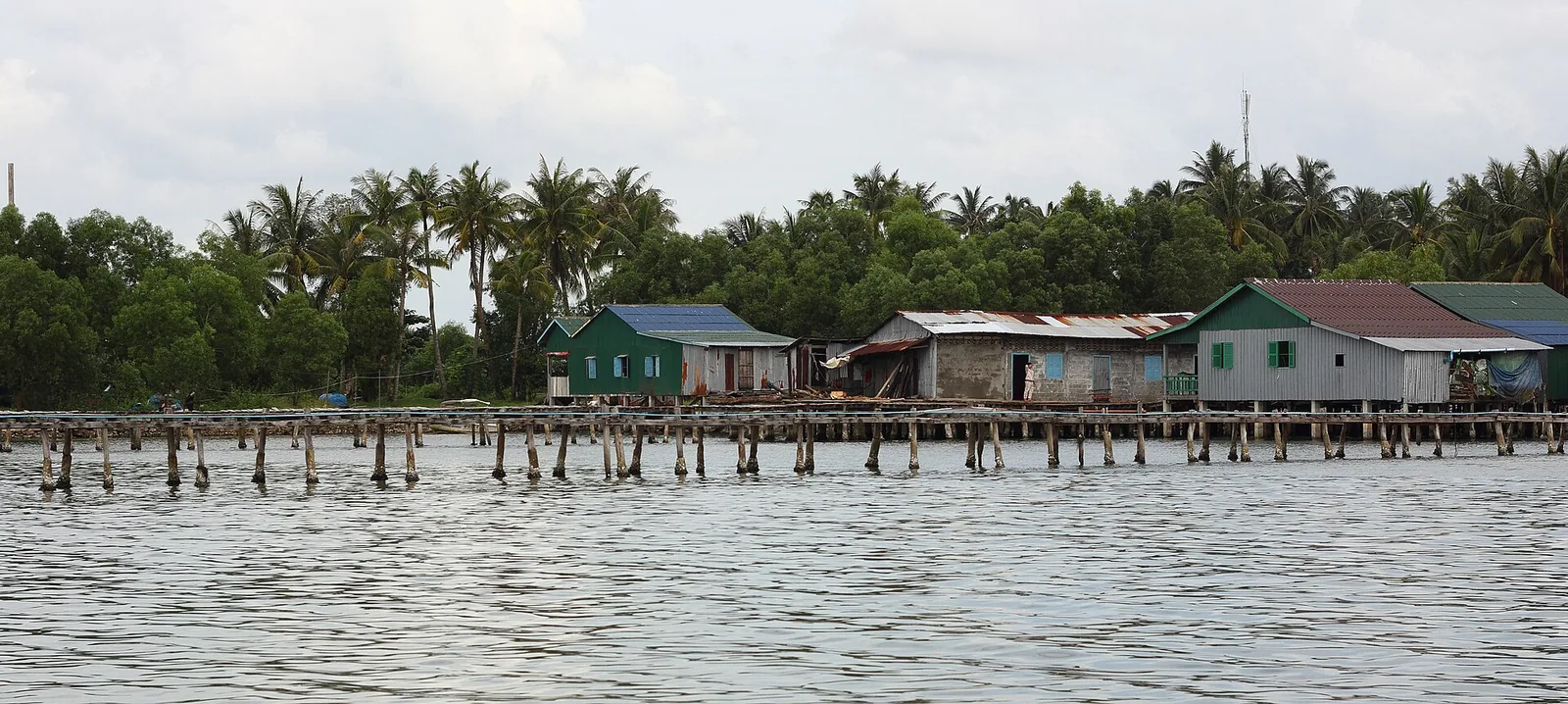 Stilt houses and fishing boats in a fishing village in Stueng Hav district on the Cambodian coast