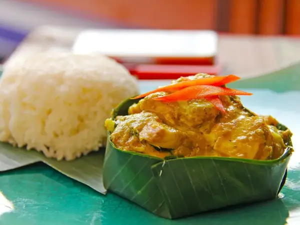 Fish amok served in a banana-leaf cup with rice