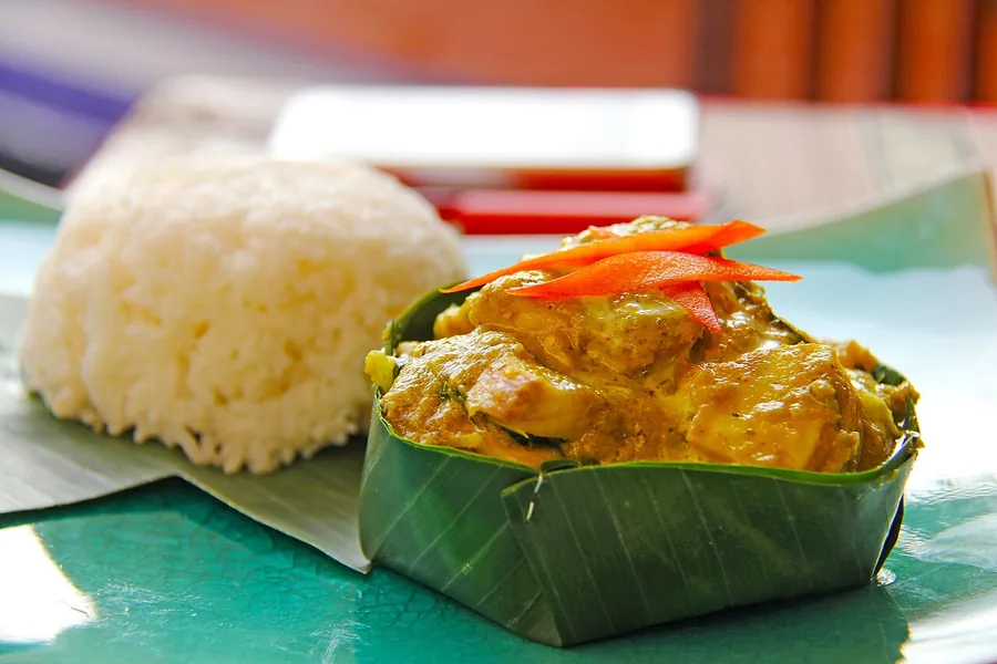 Fish amok served in a banana-leaf cup with rice