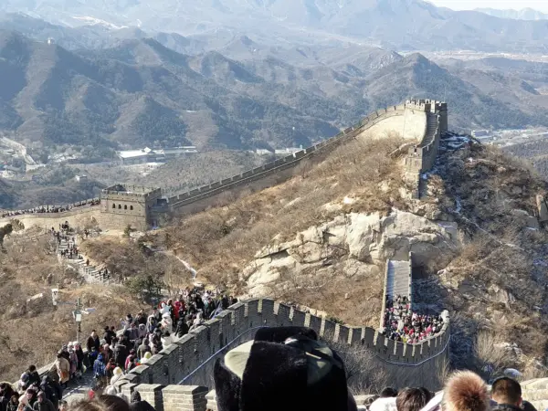 Crowded tourists in festive clothing walking along the Great Wall during the Spring Festival.