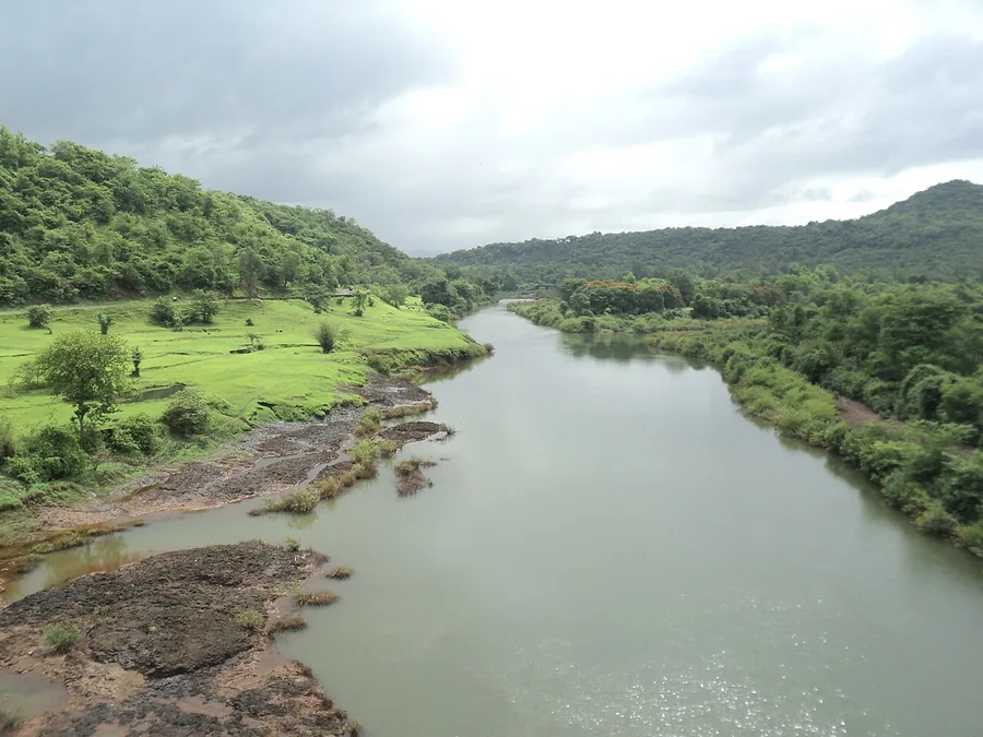 The Kali River flowing between green, forested banks