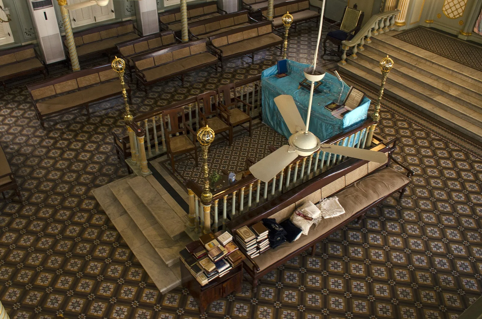 Inside Keneseth Eliyahoo Synagogue: wooden pews, vaulted ceiling, and historic plaques