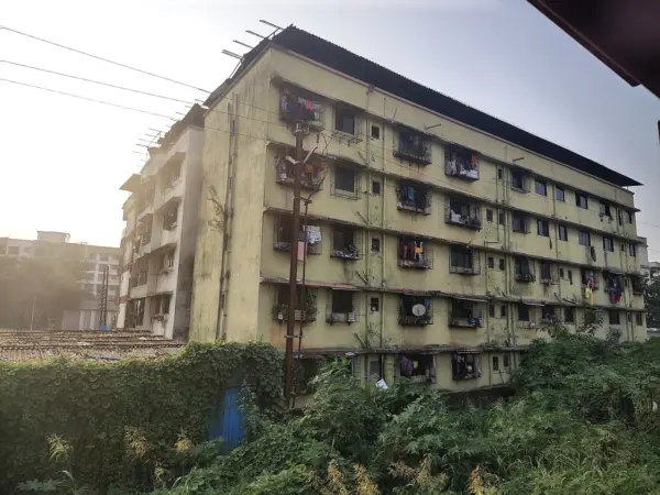Row of mixed‑age commercial buildings lining a busy Mumbai street