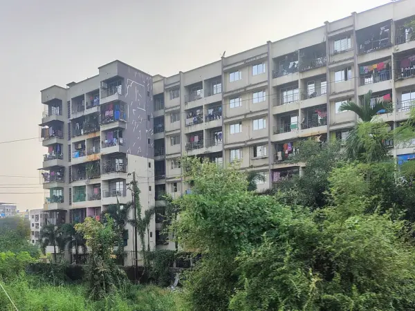 Cluster of high‑rise apartments and older shophouses under a clear sky