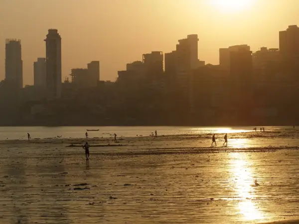 Girgaon Chowpatti beach crowded with locals and vendors, with the sea beyond