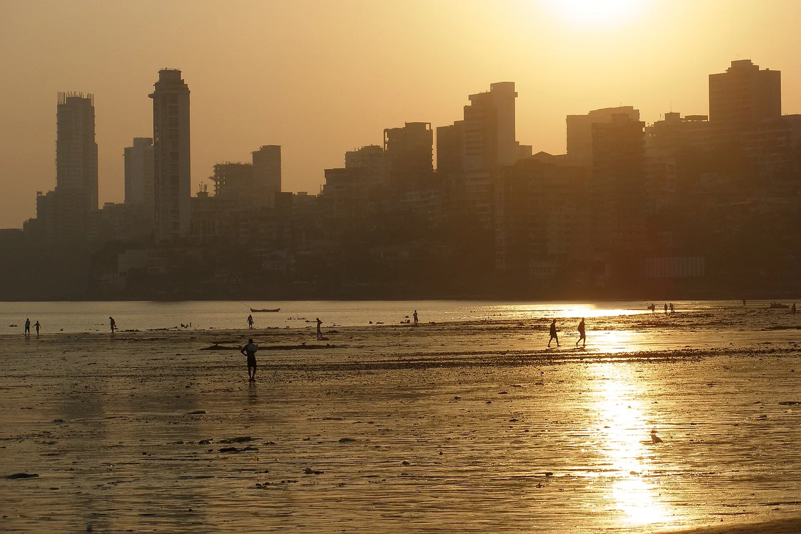 Girgaon Chowpatti beach crowded with locals and vendors, with the sea beyond