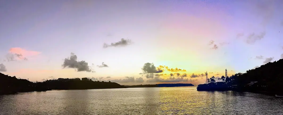Sunset over water seen from the bridge to São Jacinto Island, orange sky reflected