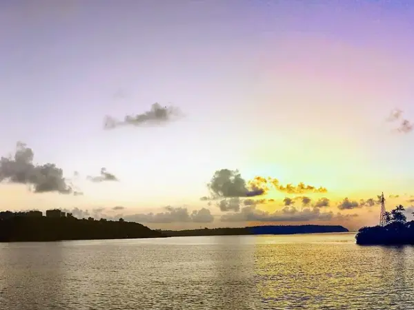 Sunset over water seen from the bridge to São Jacinto Island, orange sky reflected