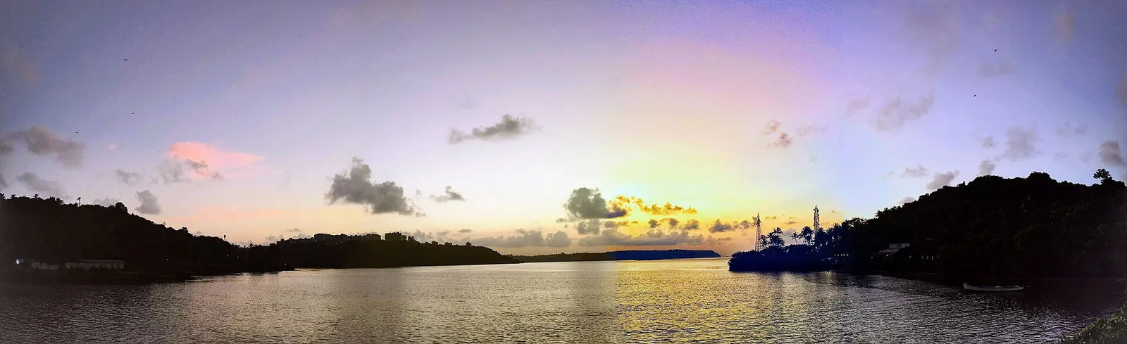 Sunset over water seen from the bridge to São Jacinto Island, orange sky reflected