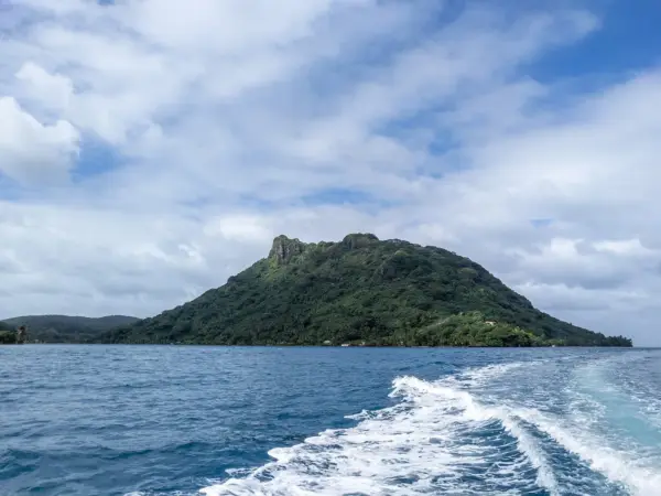 A forested peak on Huahine seen from a boat on the lagoon