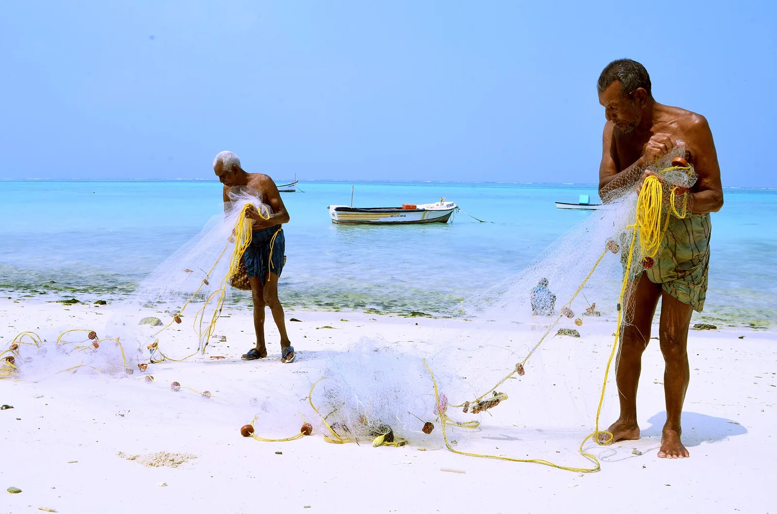 Fishermen working with nets on the beach at Kavaratti, Lakshadweep