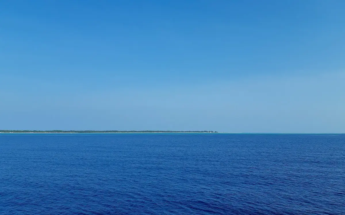 The deep blue Lakshadweep Sea near Kadmat, with the island on the horizon