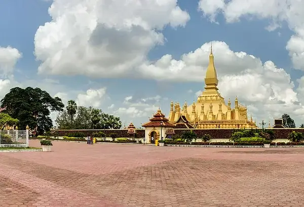 The golden Pha That Luang stupa in Vientiane with the statue of King Setthathirat in front