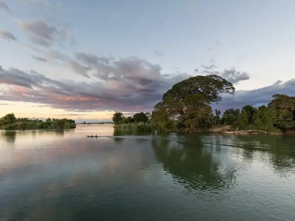A wooden boat on the Mekong at sunset, seen from Don Det in Si Phan Don