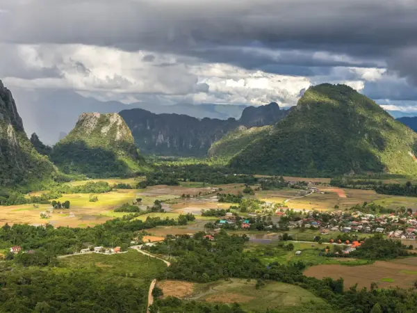 Karst peaks rising above green rice fields near Vang Vieng, seen from Mount Nam Xay