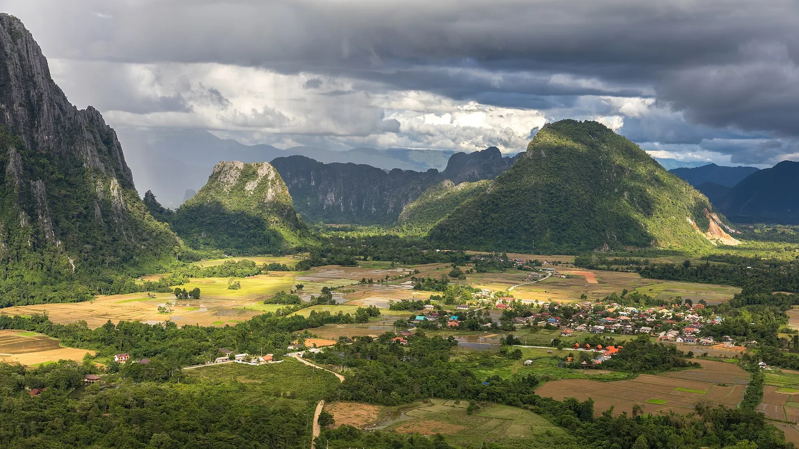 Karst peaks rising above green rice fields near Vang Vieng, seen from Mount Nam Xay