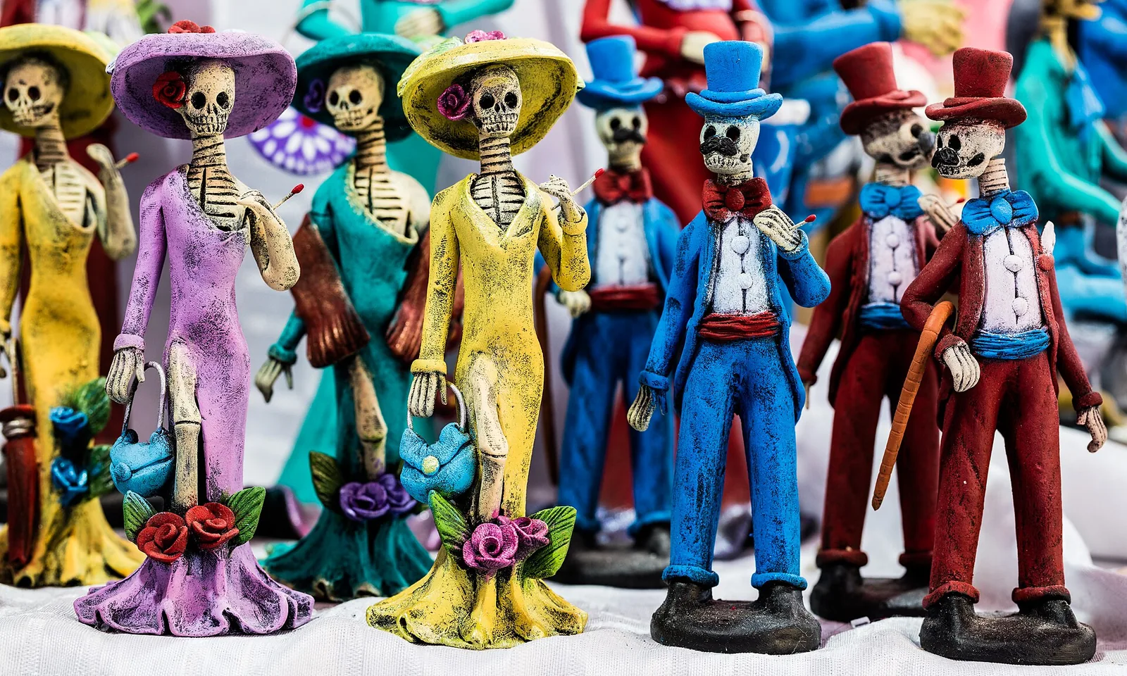 Colorful Catrina skeletons with floral hats, typical of Day of the Dead celebrations in Mexico