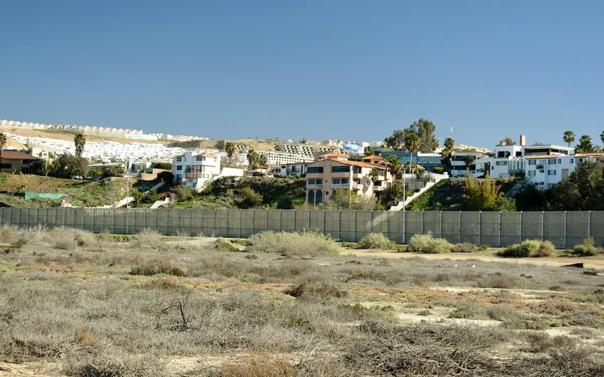 Border fence and desert landscape marking the United States‑Mexico boundary