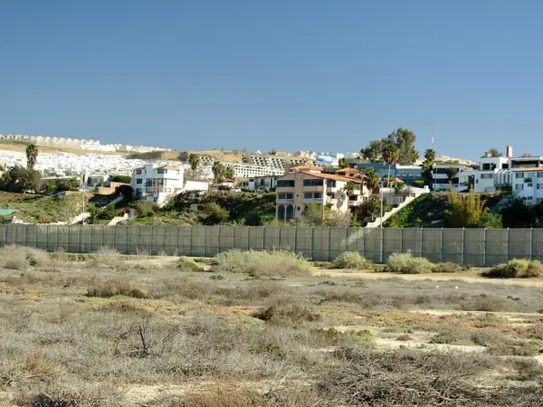 Border fence and desert landscape marking the United States‑Mexico boundary