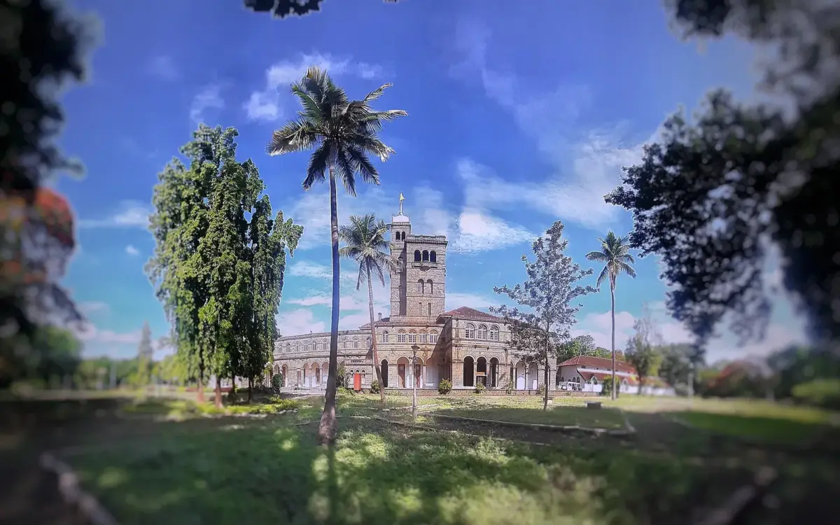 Historic university buildings with red brick facades and leafy courtyards at Savitribai Phule Pune University