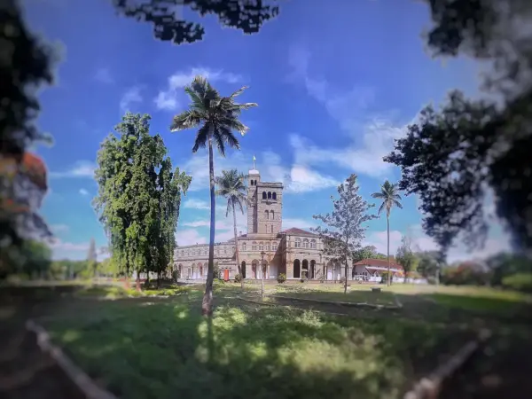 Historic university buildings with red brick facades and leafy courtyards at Savitribai Phule Pune University