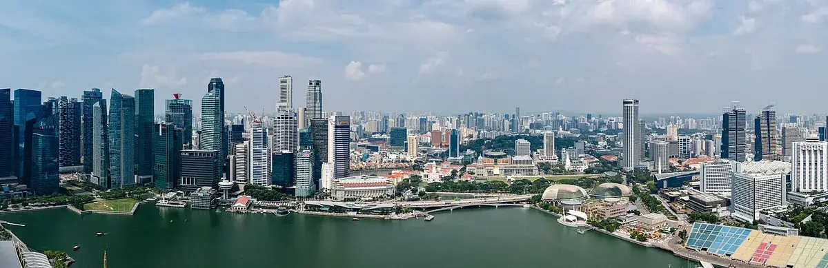 Panoramic shot from Marina Bay Sands SkyPark overlooking Marina Bay’s water, skyscrapers and the iconic hotel silhouette