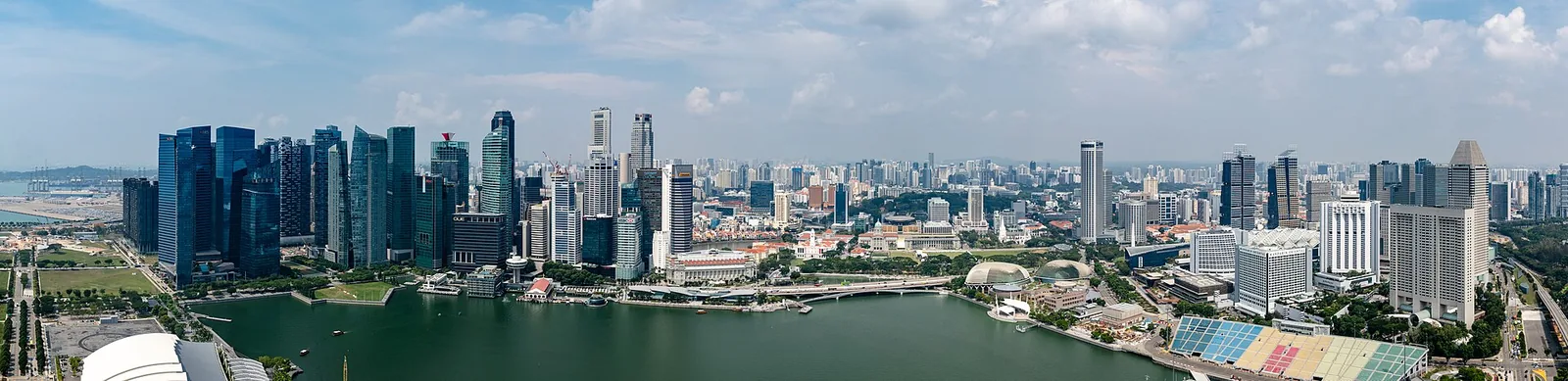 Panoramic shot from Marina Bay Sands SkyPark overlooking Marina Bay’s water, skyscrapers and the iconic hotel silhouette