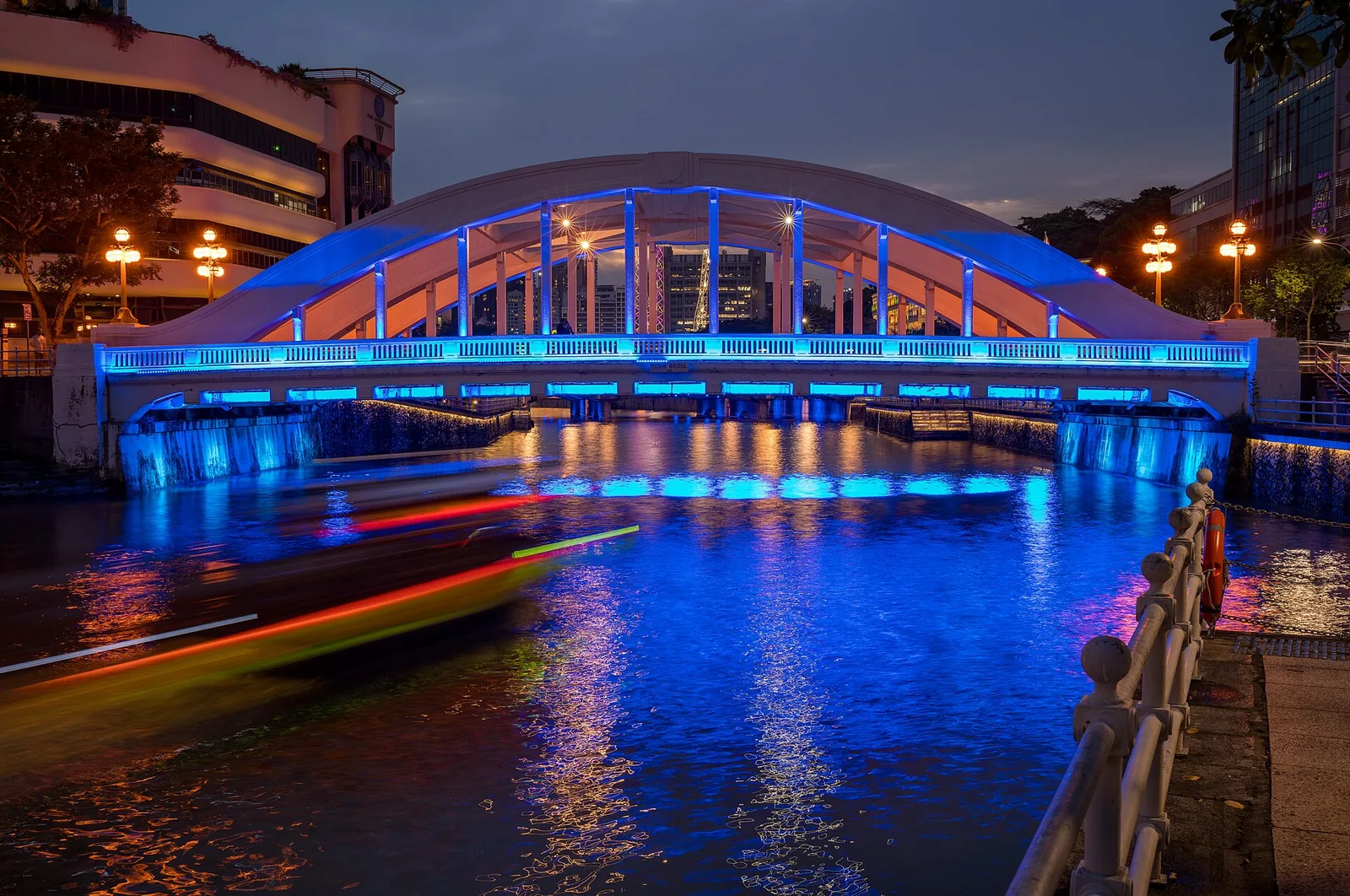 Elgin Bridge spanning the Singapore River with its box‑girder structure and historic stone arches linking downtown to the…
