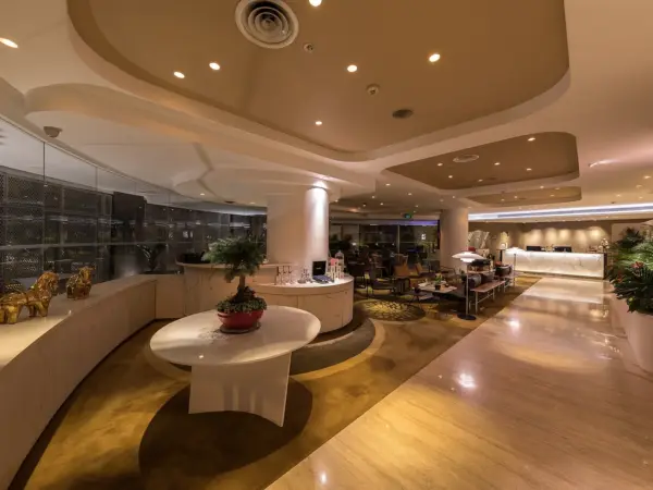 Wangz Hotel lounge interior featuring polished parquet floor, curved walls, decorative pillars, ceiling details and a round…